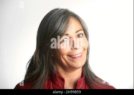 Nahaufnahme eines schönen lächelnden älteren Frau mit grauen Haaren und einer roten Jacke. Stockfoto