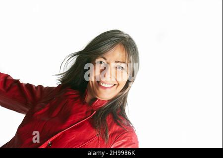 Nahaufnahme eines schönen lächelnden älteren Frau mit grauen Haaren und einer roten Jacke. Stockfoto