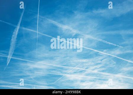 Kondensstreifen oder Kondensstreifen mit Wolkenlinien über dem Hintergrund des blauen Himmels. Hochwertige Fotos Stockfoto