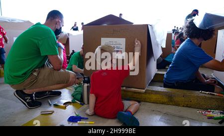 Yigo, Usa. 04th Dez 2021. Freiwillige packen gespendete Güter und schmücken Lufttropfenbündel mit Botschaften zur Unterstützung der jährlichen Operation Christmas Drop 70th auf der Andersen Air Force Base am 4. Dezember 2021 in Yigo, Guam. Jedes Jahr im Dezember werden die Luftbesatzungen 55 Inselnationen im gesamten Südost-Pazifik Nahrungsmittel, Vorräte, Unterrichtsmaterialien und Werkzeuge von AirDrop spenden. Kredit: 1lt. Jade Watkins/US Airforce Foto/Alamy Live News Stockfoto