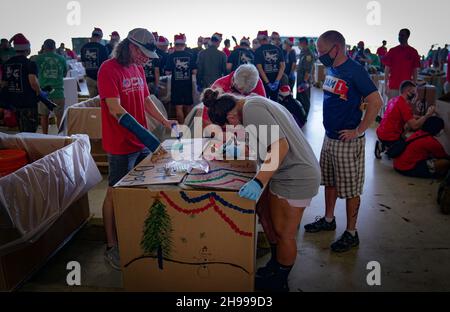 Yigo, Usa. 04th Dez 2021. Freiwillige packen gespendete Güter und schmücken Lufttropfenbündel mit Botschaften zur Unterstützung der jährlichen Operation Christmas Drop 70th auf der Andersen Air Force Base am 4. Dezember 2021 in Yigo, Guam. Jedes Jahr im Dezember werden die Luftbesatzungen 55 Inselnationen im gesamten Südost-Pazifik Nahrungsmittel, Vorräte, Unterrichtsmaterialien und Werkzeuge von AirDrop spenden. Kredit: 1lt. Jade Watkins/US Airforce Foto/Alamy Live News Stockfoto