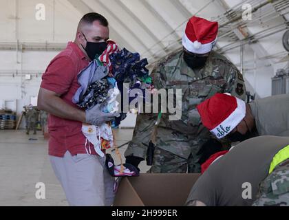 Yigo, Usa. 04th Dez 2021. Freiwillige packen gespendete Güter und schmücken Lufttropfenbündel mit Botschaften zur Unterstützung der jährlichen Operation Christmas Drop 70th auf der Andersen Air Force Base am 4. Dezember 2021 in Yigo, Guam. Jedes Jahr im Dezember werden die Luftbesatzungen 55 Inselnationen im gesamten Südost-Pazifik Nahrungsmittel, Vorräte, Unterrichtsmaterialien und Werkzeuge von AirDrop spenden. Kredit: MSgt. Richard Ebensberger/US Airforce Photo/Alamy Live News Stockfoto