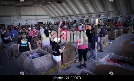 Yigo, Usa. 04th Dez 2021. Freiwillige packen die gespendeten Waren in Lufttropfenbündel mit während der Vorbereitungen für die jährliche Operation Christmas Drop 70th auf der Andersen Air Force Base am 4. Dezember 2021 in Yigo, Guam. Jedes Jahr im Dezember werden die Luftbesatzungen 55 Inselnationen im gesamten Südost-Pazifik Nahrungsmittel, Vorräte, Unterrichtsmaterialien und Werkzeuge von AirDrop spenden. Kredit: MSgt. Richard Ebensberger/US Airforce Photo/Alamy Live News Stockfoto