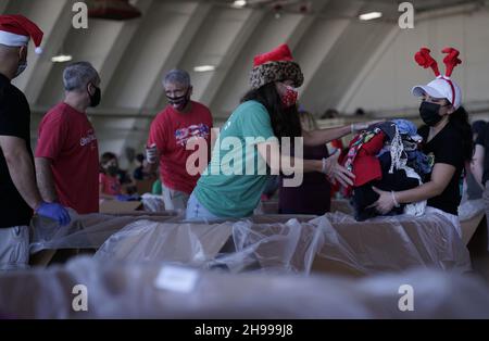 Yigo, Usa. 04th Dez 2021. Freiwillige packen die gespendeten Waren in Lufttropfenbündel mit während der Vorbereitungen für die jährliche Operation Christmas Drop 70th auf der Andersen Air Force Base am 4. Dezember 2021 in Yigo, Guam. Jedes Jahr im Dezember werden die Luftbesatzungen 55 Inselnationen im gesamten Südost-Pazifik Nahrungsmittel, Vorräte, Unterrichtsmaterialien und Werkzeuge von AirDrop spenden. Kredit: MSgt. Richard Ebensberger/US Airforce Photo/Alamy Live News Stockfoto