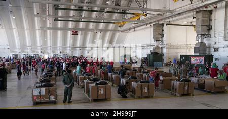 Yigo, Usa. 04th Dez 2021. Freiwillige packen die gespendeten Waren in Lufttropfenbündel mit während der Vorbereitungen für die jährliche Operation Christmas Drop 70th auf der Andersen Air Force Base am 4. Dezember 2021 in Yigo, Guam. Jedes Jahr im Dezember werden die Luftbesatzungen 55 Inselnationen im gesamten Südost-Pazifik Nahrungsmittel, Vorräte, Unterrichtsmaterialien und Werkzeuge von AirDrop spenden. Kredit: MSgt. Richard Ebensberger/US Airforce Photo/Alamy Live News Stockfoto