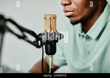 Nahaufnahme eines afroamerikanischen Mannes, der zu Hause mit dem Mikrofon spricht, während er Podcast aufzeichnet Stockfoto