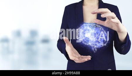 Das moderne Konzept des Cyberhirns. Virtuelles holographisches Gehirnsymbol mit zwei Händen und hellem unscharfem Hintergrund. Künstliche Intelligenz Stockfoto