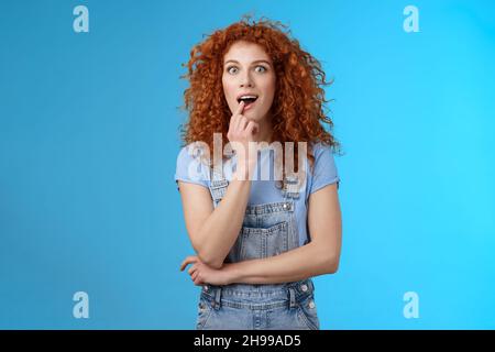 Wow, Erzähl mir mehr. Mädchen spannend hören Details stehend erstaunt Wunsch Geschmack neue Eis Geschmack berühren Lippe süchtig starren Kamera Aspiration wollen, dass Stockfoto