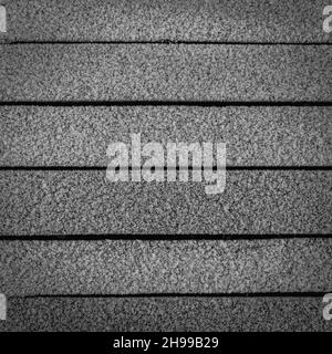 Eine Wand aus Holzplanken, die an einem frostigen Morgen mit weißem Frost bedeckt ist. Stockfoto