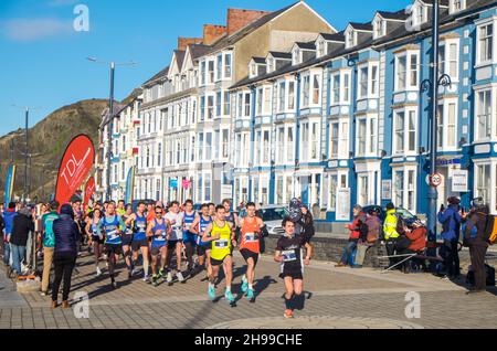 Läufer,Teilnehmer,in,Aberystwyth 10k,Kilometer,Lauf,Rennen,durchgeführt,in,Aberystwyth,Cardigan Bay,Küste,Küste,an,A,sonnig,aber,windig,Dezember,Winter,Winter,Tag,Mittel,Westen,Wales,Ceredigion,Ceredigion County,Welsh,GB,UK,Vereinigtes Königreich,Großbritannien,Großbritannien,Britisch,Europa,europäisch, Stockfoto