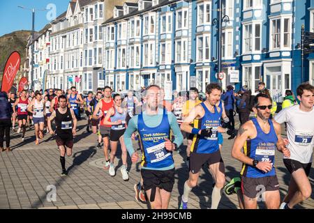 Läufer,Teilnehmer,in,Aberystwyth 10k,Kilometer,Lauf,Rennen,durchgeführt,in,Aberystwyth,Cardigan Bay,Küste,Küste,an,A,sonnig,aber,windig,Dezember,Winter,Winter,Tag,Mittel,Westen,Wales,Ceredigion,Ceredigion County,Welsh,GB,UK,Vereinigtes Königreich,Großbritannien,Großbritannien,Britisch,Europa,europäisch, Stockfoto