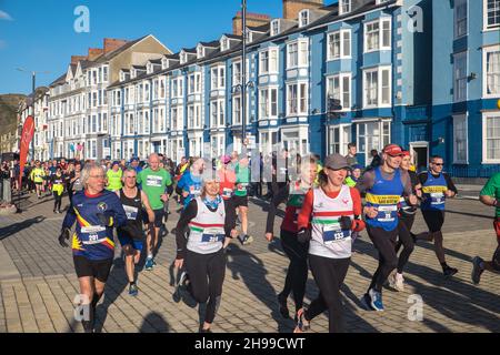 Läufer,Teilnehmer,in,Aberystwyth 10k,Kilometer,Lauf,Rennen,durchgeführt,in,Aberystwyth,Cardigan Bay,Küste,Küste,an,A,sonnig,aber,windig,Dezember,Winter,Winter,Tag,Mittel,Westen,Wales,Ceredigion,Ceredigion County,Welsh,GB,UK,Vereinigtes Königreich,Großbritannien,Großbritannien,Britisch,Europa,europäisch, Stockfoto