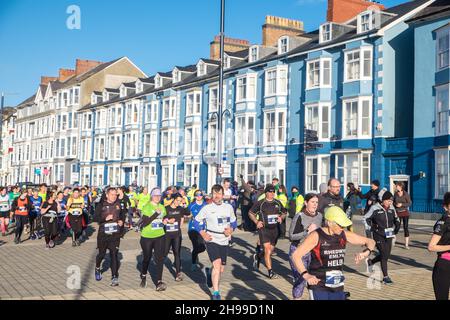 Läufer,Teilnehmer,in,Aberystwyth 10k,Kilometer,Lauf,Rennen,durchgeführt,in,Aberystwyth,Cardigan Bay,Küste,Küste,an,A,sonnig,aber,windig,Dezember,Winter,Winter,Tag,Mittel,Westen,Wales,Ceredigion,Ceredigion County,Welsh,GB,UK,Vereinigtes Königreich,Großbritannien,Großbritannien,Britisch,Europa,europäisch, Stockfoto