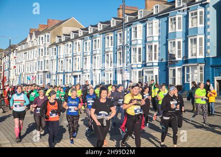 Läufer,Teilnehmer,in,Aberystwyth 10k,Kilometer,Lauf,Rennen,durchgeführt,in,Aberystwyth,Cardigan Bay,Küste,Küste,an,A,sonnig,aber,windig,Dezember,Winter,Winter,Tag,Mittel,Westen,Wales,Ceredigion,Ceredigion County,Welsh,GB,UK,Vereinigtes Königreich,Großbritannien,Großbritannien,Britisch,Europa,europäisch, Stockfoto