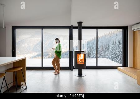 Frau in einer modernen Wohnung mit tollem Blick auf die Berge Stockfoto