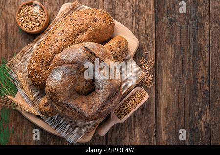 Frisches Vollkornbrot auf einem Holzhintergrund. Draufsicht, Kopierbereich. Stockfoto