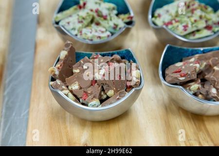 Eine Nahaufnahme verschiedener Snacks in verschiedenen Schüsseln auf einer Holzoberfläche Stockfoto