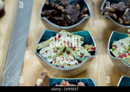 Eine Nahaufnahme verschiedener Snacks in verschiedenen Schüsseln auf einer Holzoberfläche Stockfoto