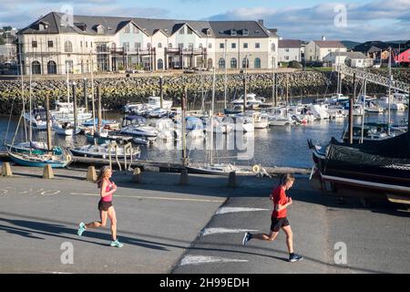 Läufer,Passing,Aberystwyth Harbour,Aberystwyth Marina,Teilnahme,an,Aberystwyth 10k,Kilometer,Lauf,Rennen,durchgeführt,in,Aberystwyth,Cardigan Bay,Küste,Küste,auf,A,sonnig,aber,windig,Dezember,Winter,Winter,Tag,Mittel,Westen,Wales,Ceredigion,Ceredigion County,Walisisch,GB,UK,Europa,Großbritannien Stockfoto