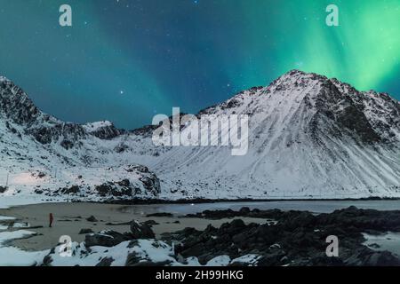 Die atemberaubenden Nordlichter über einem See und felsigen Bergen in Lofoten, Norwegen Stockfoto