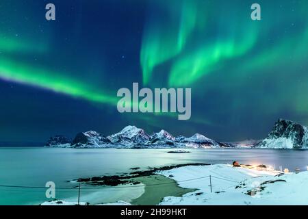 Die atemberaubenden Nordlichter über einem See und felsigen Bergen in Lofoten, Norwegen Stockfoto