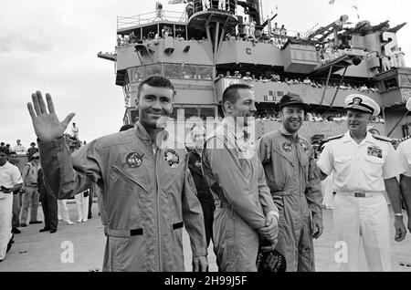 Der Konteradmiral Donald C. Davis, Kommandant der Task Force 130, der Pacific Recovery Forces für die bemannten Raumfahrzeuge Missionen, begrüßt die Apollo 13 Besatzungsmitglieder an Bord der USS Iwo Jima, dem primären Rückgewinnungsschiff für die Apollo 13 Mission. Die Besatzungsmitglieder (von links), die Astronauten Fred W. Haise Jr. (winkend), Mondmodulpilot; John L. Swigert Jr., Kommandozeilenpilot; und James A. Lovell Jr., Kommandant; wurden mit dem Hubschrauber zum Schiff transportiert, nachdem sie nur etwa vier Meilen von der USS Iwo Jima entfernt einen sanften Spritzguss hinuntergefahren hatten. Spritzwasserfall um 12:07:44 Uhr (CST),