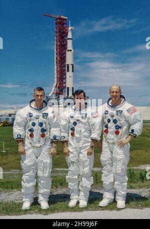 Hauptmannschaft der Apollo 10 Mondbahn-Mission. Von links nach rechts befinden sich Eugene A. Cernan, Pilot des Mondmoduls; John W. Young, Pilot des Befehlsmoduls; und Thomas P. Stafford, Kommandant. Im Hintergrund ist das Raumfahrzeug Apollo 10 auf Pad B, Launch Complex 39, Kennedy Space Center, Florida. Stockfoto