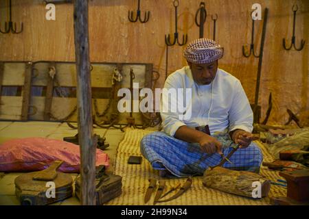 Ein traditioneller arabischer Schmied, der im Katara-Kulturdorf, Doha, Katar, bei Tageslicht arbeitet. Stockfoto