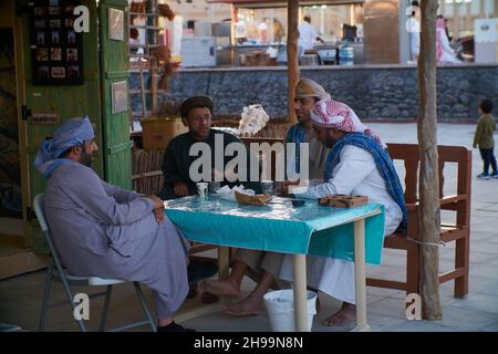 Gruppe traditioneller arabischer Fischer, die im Katara-Kulturdorf in Doha, Katar, während des elften traditionellen Dhow-Festivals in Katara, Tageslichtansicht sitzen Stockfoto