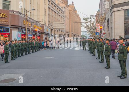 Shanghai, China - 31. Dezember 2016: Menschenmenge und Armee patrouillieren vor Neujahr auf der zentralen Stadtstraße. Stockfoto