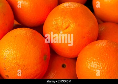 Orangen, die zum Verkauf stehen, bilden einen natürlichen Fruchthintergrund. Stockfoto