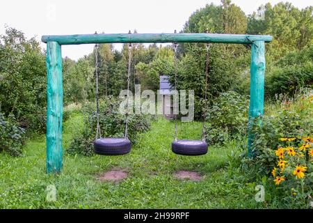 Selbstmades Flügel aus Reifen und Metallketten im Sommergarten. Stockfoto