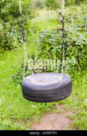 Selbstmades Flügel aus Reifen und Metallketten im Sommergarten. Stockfoto