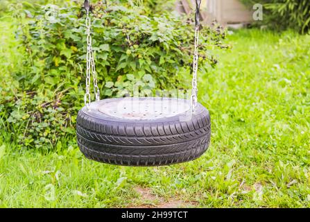 Selbstmades Flügel aus Reifen und Metallketten im Sommergarten. Stockfoto