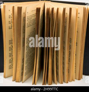 Offenes, stehendes Buch mit vergoldeten Kanten. Es ist ein antikes Buch mit deutschem Text. Stockfoto