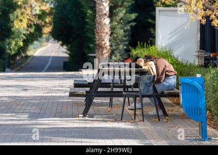 Ein Schüler, der nach dem Unterricht auf dem Schulhof einschläft Stockfoto