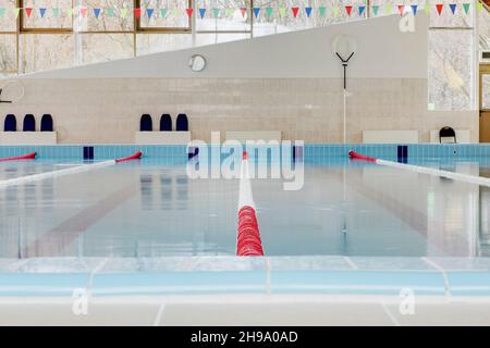 Hallenbad, rote und weiße Trennwände in den Schwimmbahnen, Blick auf die Oberfläche. Stockfoto
