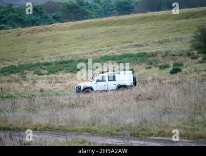 Geländewagen mit Geländewagen im Geländewagen, der über Schlamm und Wasser geloggte Gebiete fährt, Salisbury Plain Wilts UK. Land Rover Defender 110 Stockfoto