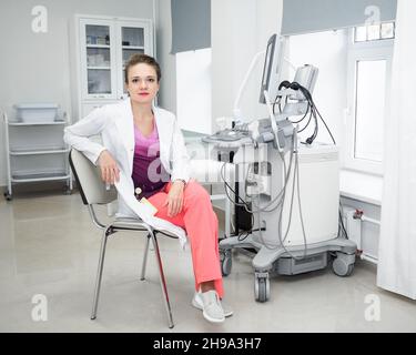 Hochqualifizierte professionelle, attraktive Ärztin, Sonografin, die lächelt und die Kamera anschaut. Stockfoto