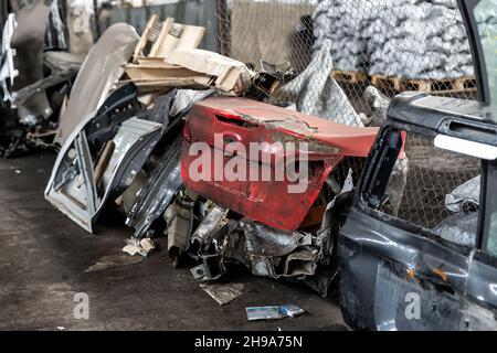 Haufen alter rostiger, zerlegter Autoteile in der Halle für die Abfalllagerung in der Werkstatt. Fahrzeugbergung Demontage Garage. Iron Auto Spare Details Trunk Stockfoto