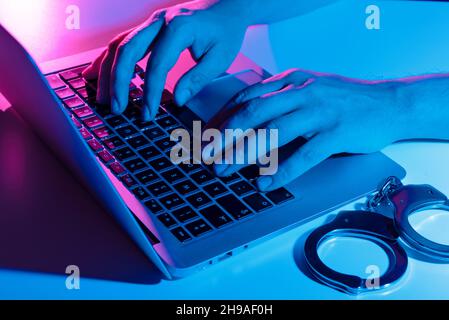 Konzept der Cyberkriminalität mit Mann in Handschellen. Phishing-Angriff, Malware Stockfoto