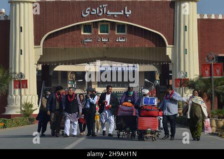 Lahore, Punjab, Pakistan. 4th Dez 2021. Hindu-Anhänger aus Indien, die zu Fuß durch die Wagah-Grenze nach Pakistan kommen, während mehr als hundert Anhänger zur Teilnahme an der 313th. Geburtstagfeier des Shiv Avtari Satguru Sant Shadaram Sahib Shadani Darbar Hayat Pitaphi Distt Ghotki in der Provinz Sindh in Lahore eintreffen. (Bild: © Rana Sajid Hussain/Pacific Press via ZUMA Press Wire) Stockfoto