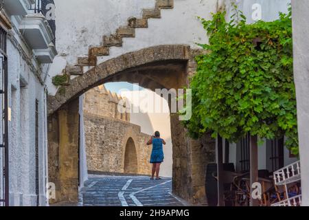 Touristen, die auf einer gepflasterten Straße an der Stadtmauer spazieren, Vejer de la Frontera, Provinz Cáááiz, Autonome Gemeinschaft Andalusien, Spanien Stockfoto