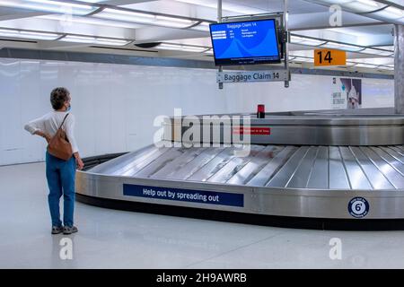 Denver Colorado USA 4 2021. Juni; Eine maskierte Frau wartet auf ihr Gepäck am internationalen Flughafen Denver in Colorado Stockfoto