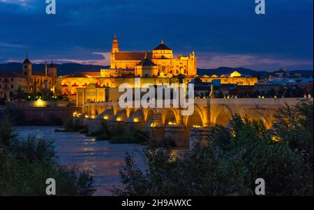 Nachtansicht der römischen Brücke auf dem Guadalquivir-Fluss und der Mezquita-Kathedrale (Moschee-Kathedrale oder große Moschee von Cordoba), Cordoba, Spanien Stockfoto