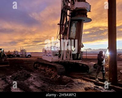 Wyoming USA April 29 2021; ein Schweißer arbeitet an einem Bohrgerät, wenn die Sonne in diesem rustikalen Ölfeld nach Westen aufgeht Stockfoto