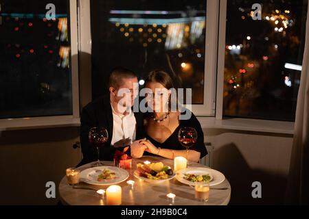 Romantisches Abendessen für zwei mit Kerzen, Datum bei Kerzenschein mit Wein, verliebter Partner am valentinstag, Mann und Frau-Beziehungsurlaub zu Hause Stockfoto