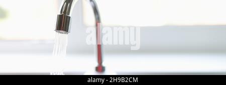 Reines Wasser fließt aus dem Wasserhahn in der Nähe der Küche Stockfoto