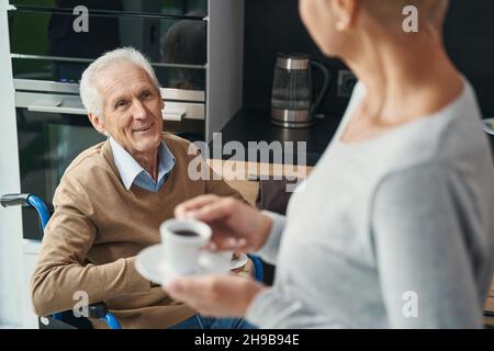 Nahaufnahme eines glücklichen Rollstuhlfahrers, der seine Frau ansieht Stockfoto