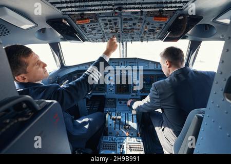 Zwei Piloten, die während des Abfahrens Schalter wechseln Stockfoto